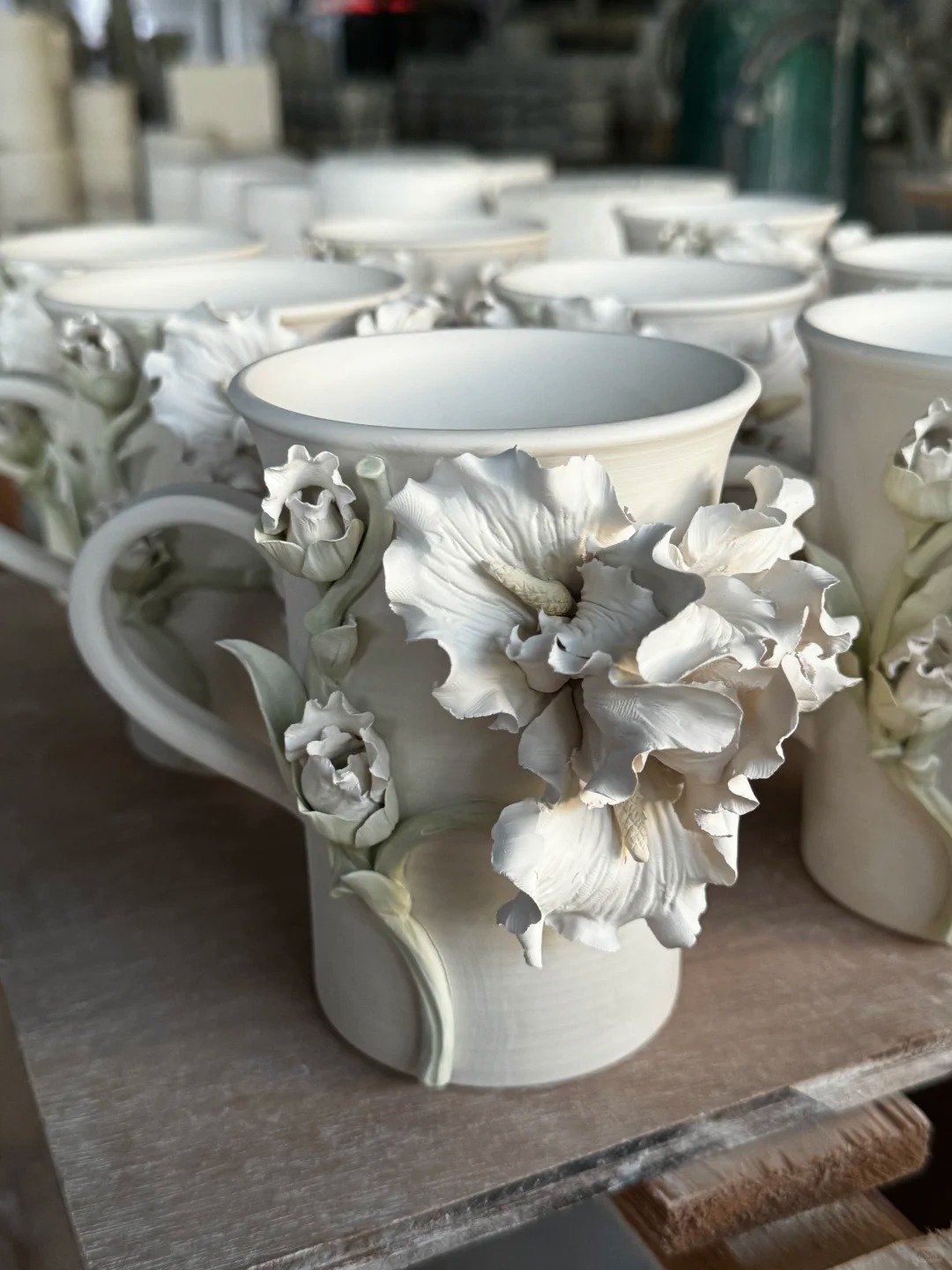 White ceramic cup decorated with purple iris ceramic flowers and yellow details