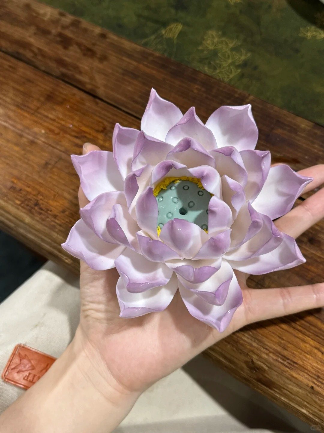 Purple lotus ceramic incense holder with sculpted petals on a wooden surface