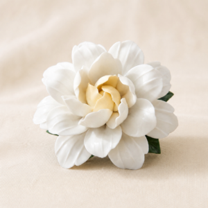 White gardenia ceramic flower diffuser and incense holder on a warm cream studio background